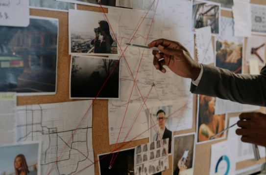 An investigative corkboard filled with papers and pictures.